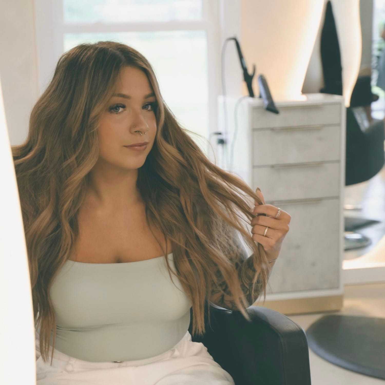 Portrait of Cas, a professional stylist at Stella Beauty, showcasing their expertise and style.